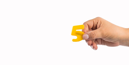 Number 5 in plastic, hand holds - Text spaceの写真素材
