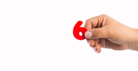 Number 6 in plastic, hand holds - Text space