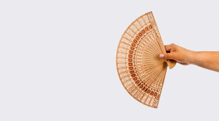 hand holding wooden folding fan - White backgroundの写真素材