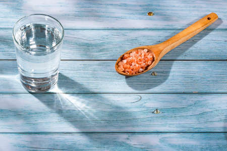 Fine-grain pink Himalayan salt and crystals - Glass of waterの写真素材