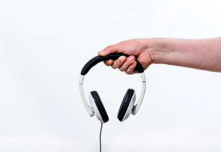 Latin hand holding white headphones - Text spaceの写真素材