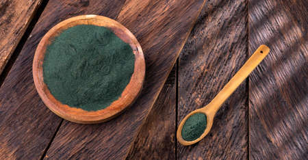 Fresh spirulina powder in a bowl on a wooden backgroundの写真素材