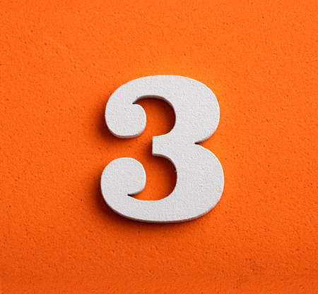 Number three - white number in wood on orange backgroundの写真素材