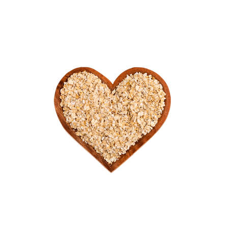Oat flakes in the heart shaped bowl - Avena sativaの写真素材