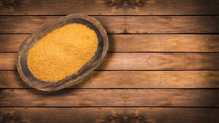 Saccharum officinarum - Organic brown sugar in the wooden bowl