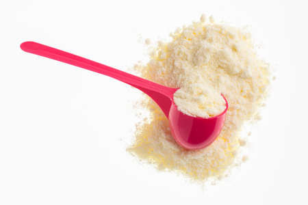 Powdered or dehydrated milk in the pink spoonの写真素材