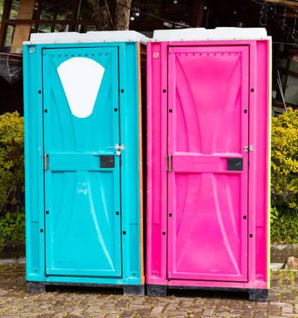The two portable toilets in pink for women and blue for menの写真素材