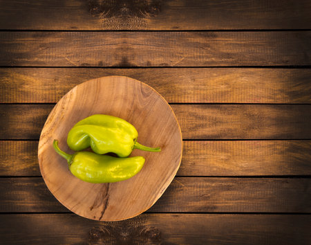 Capsicum annuum - Two green peppers in the wooden bowlの写真素材