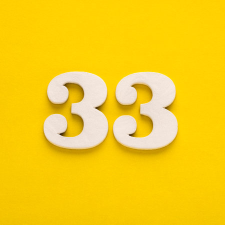 Number 33 - Two figures in white on a yellow backgroundの写真素材