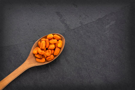 Crunchy salty chili corn - Zea mays. Toasted snacks on the spoon