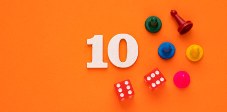 Number ten in white with pieces and gambling dice - Orange eva rubber backgroundの写真素材