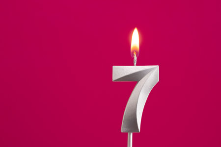 Number 7 - Silver Anniversary Candle on Rhodamine Red Backgroundの写真素材