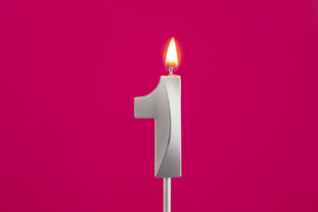 Number 1 - Silver Anniversary Candle on Rhodamine Red Backgroundの写真素材