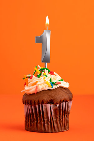 Candle number 1 - Cake birthday in orange backgroundの写真素材