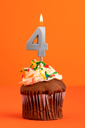 Birthday cake with candle number 4 - Orange foamy backgroundの写真素材