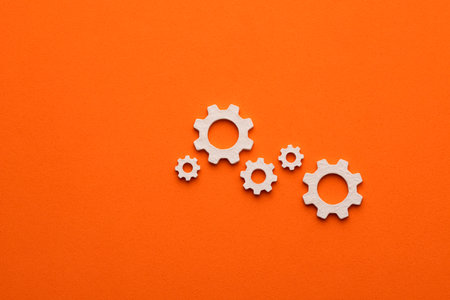 Gears on orange color background - Business mechanism concept, flat graphic resource for designの写真素材