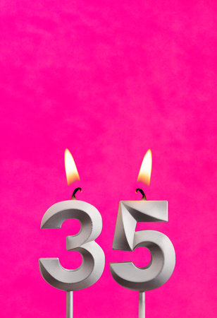 Number 35 candle - Birthday celebration on fuchsia background