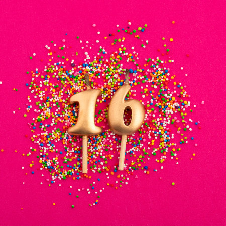 Birthday candle number 16 - Anniversary celebration in rhodamine red backgroundの写真素材