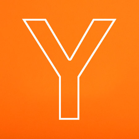 Letter Y uppercase written in white color isolated on orange foamy backgroundの写真素材