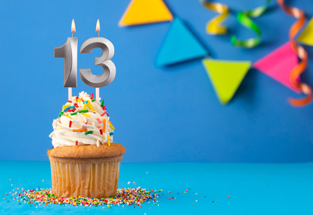 Birthday cake with candle number 13 - Blue backgroundの写真素材