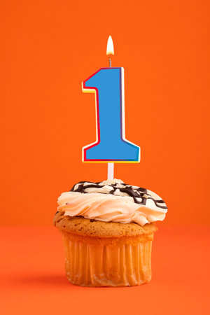 Blue number 1 candle - Birthday cake on orange background.の写真素材