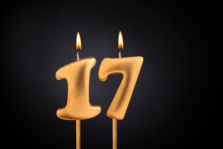 Golden candle 17 with flame - Birthday card on dark luxury backgroundの写真素材
