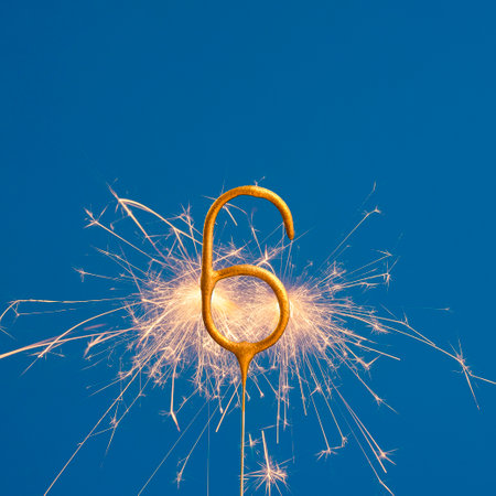 Burning sparkler number 6 - Birthday on blue backgroundの写真素材