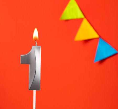 Birthday candle number 1 - Invitation card in orange backgroundの写真素材