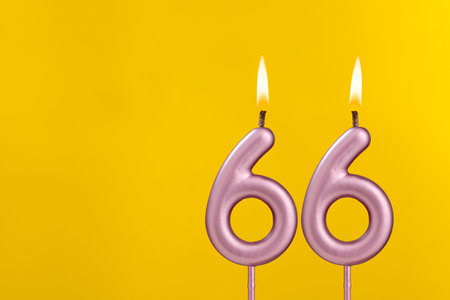 Candle 66 with flame - Birthday card on yellow luxury backgroundの写真素材