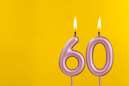 Candle 60 with flame - Birthday card on yellow luxury backgroundの写真素材