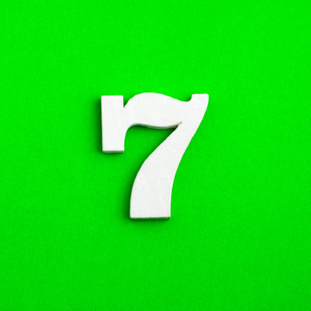 Number seven - white number in wood on green backgroundの写真素材