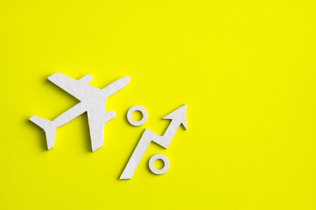 Increase in the value of plane tickets - Up arrow on yellow backgroundの写真素材