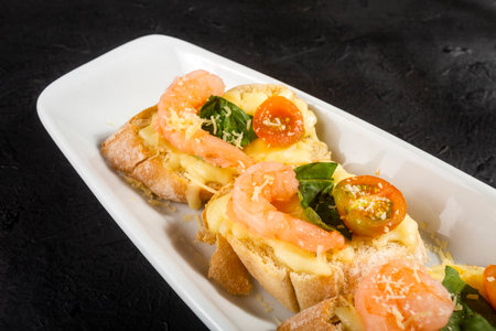 Starter or antipasto dish. Shrimp bruschetta sautÃ©ed in wine on French bread with Neapolitan sauce, basil, mozzarella cheese, cherry tomatoesの写真素材