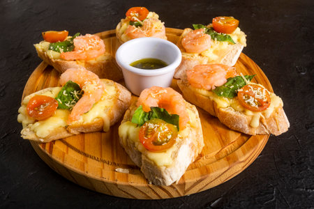 Starter or antipasto dish. Shrimp bruschetta sautÃ©ed in wine on French bread with Neapolitan sauce, basil, mozzarella cheese, cherry tomatoesの写真素材