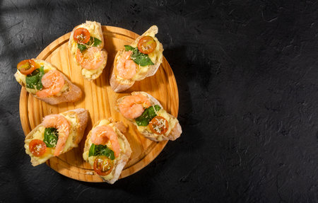 Starter or antipasto dish. Shrimp bruschetta sautÃ©ed in wine on French bread with Neapolitan sauce, basil, mozzarella cheese, cherry tomatoesの写真素材