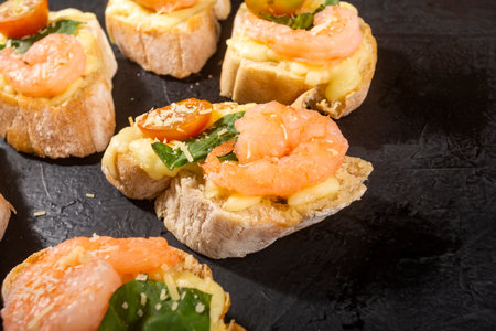 Shrimp bruschetta sautÃ©ed in wine on French bread with Neapolitan sauce, basil, mozzarella cheese, cherry tomatoesの写真素材