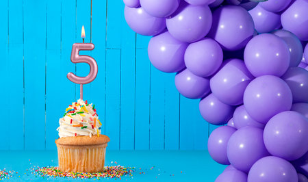 Birthday card with number 5 candle, cupcake and balloons