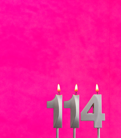 Candle 114 with flame - Birthday card in fuchsia backgroundの写真素材