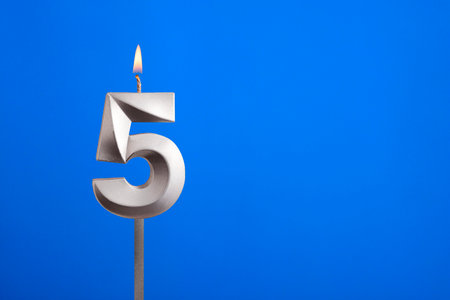 Birthday candle number 5 - Celebration card on blue backgroundの写真素材