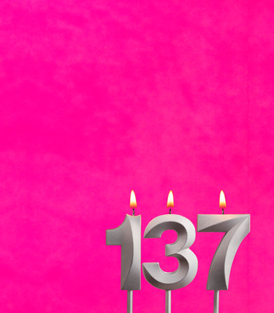 Candle number 137 - Birthday celebration on fuchsia backgroundの写真素材
