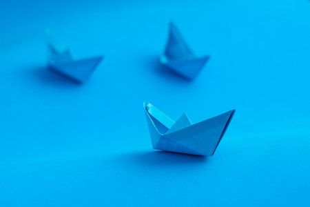 Three blue paper boats on blue background - Art for decoration