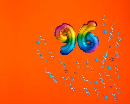 Multicolor balloon number 96 - Confetti explosion on orange background. birthday cardの写真素材