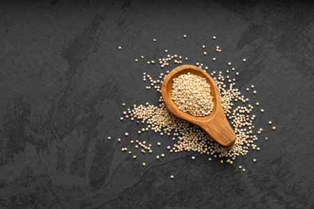 Chenopodium quinoa - White organic quinoa seeds in spoon - Rustic backgroundの写真素材