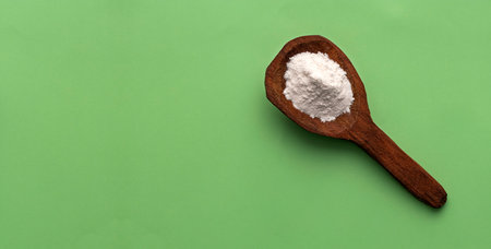 Baking Soda - Crystalline Solid compound in spoon. green backgroundの写真素材