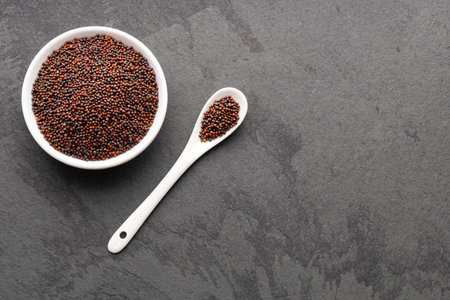 Brassica juncea - Brown mustard seeds in bowl and spoon.の写真素材