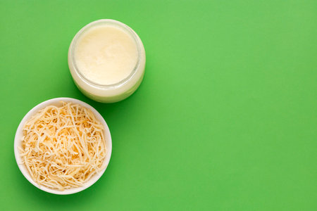 Cocos nucifera - spoon and bowl with oil and grated coconut.の写真素材