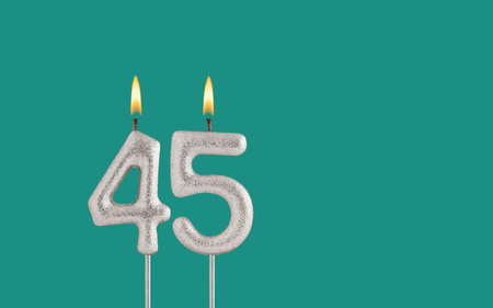 Birthday candle number 45 - Card on a green background.の写真素材