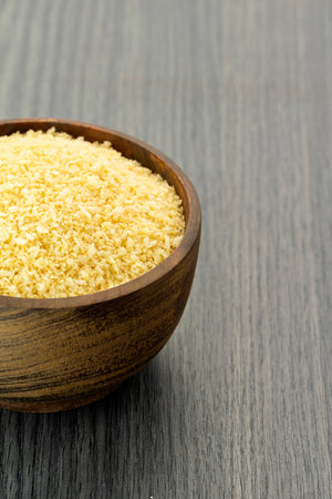 Crunchy yellow panko bread crumbs in a wooden bowl.の写真素材