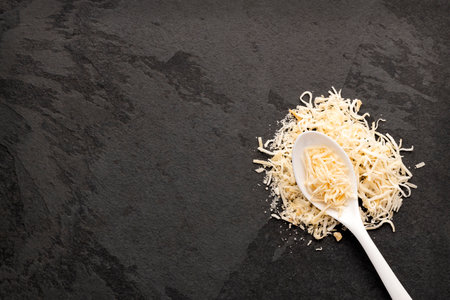 Cocos nucifera - Grated coconut with dehydrated sugar on the spoon.