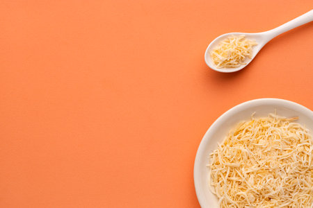 Cocos nucifera - Dehydrated coconut flakes with sugar in the bowl and spoon.